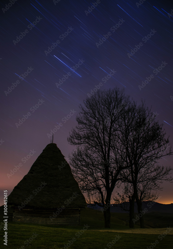 Star trails and traditional house in Dumesti village, Apuseni Mountains, Romania