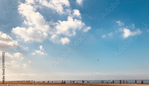People walking and enjoying sunny day at seaside in summer