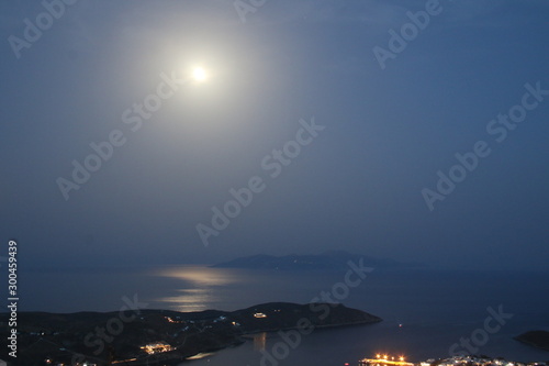 Serifos island-Greece with full moon rising over the Aegean sea and the nearby islands