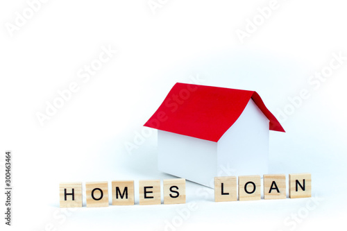 Home loans- word composed fromwooden blocks letters on White background, layout of a house with a red roof. copy space for ad text. photo