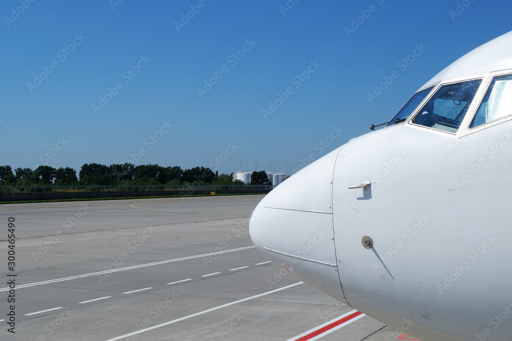 Obraz premium Airplane nose details against clear blue sky. View of jumbo-jet airliner front and nose in generic, white paint scheme.