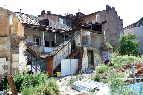 Architecture detail of damaged house dilapidated old building wall. Private abandoned home fall to ruin. Sunny day, horizontal orientation, nobody.