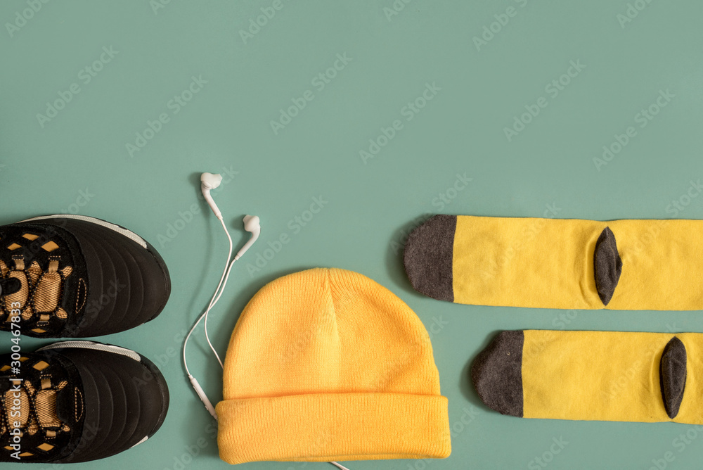 White Sneakers with headphones on blue wooden background. Accessories for  sports. Running shoes and yellow hat. Music concept. Flat lay, minimal.  Stock Photo | Adobe Stock