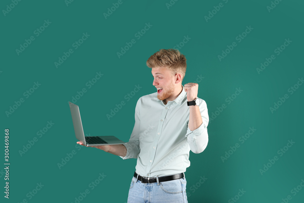 Emotional man with laptop on green background Emotional man with laptop on green background