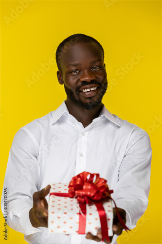Portrait of cute African man giving a gift © IVASHstudio