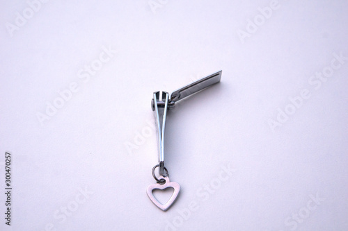 Cute little nail cutter with heart shape key chain on white background © Atthapon