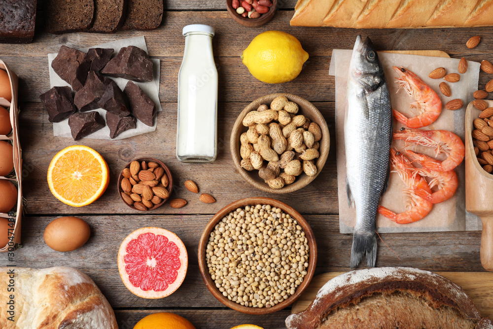 Flat lay composition of different products on wooden table. Food allergy concept Flat lay composition of different products on wooden table. Food allergy concept