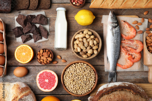 Flat lay composition of different products on wooden table. Food allergy concept © New Africa