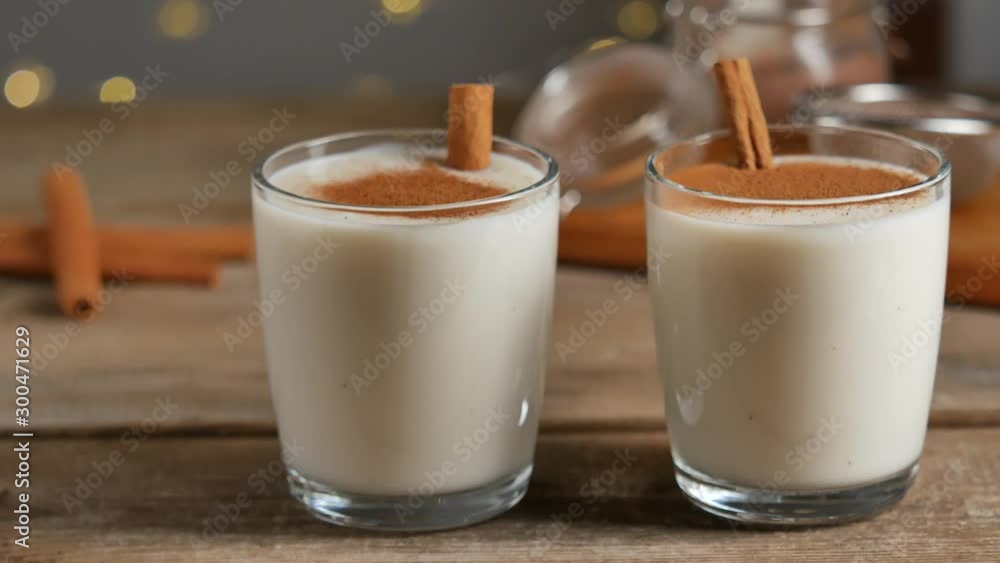 Homemade traditional Christmas eggnog drinks in the glasses with cinnamon. Homemade traditional Christmas eggnog drinks in the glasses with cinnamon.