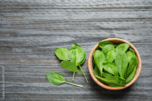 Fresh green healthy spinach on dark wooden table, flat lay. Space for text