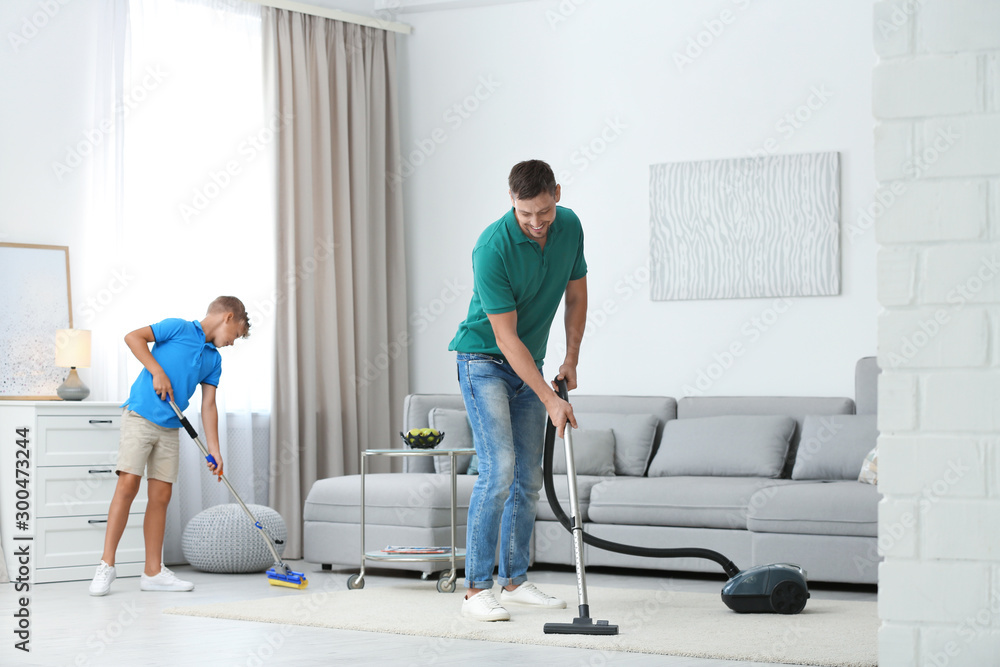 Dad and son cleaning living room together Dad and son cleaning living room together