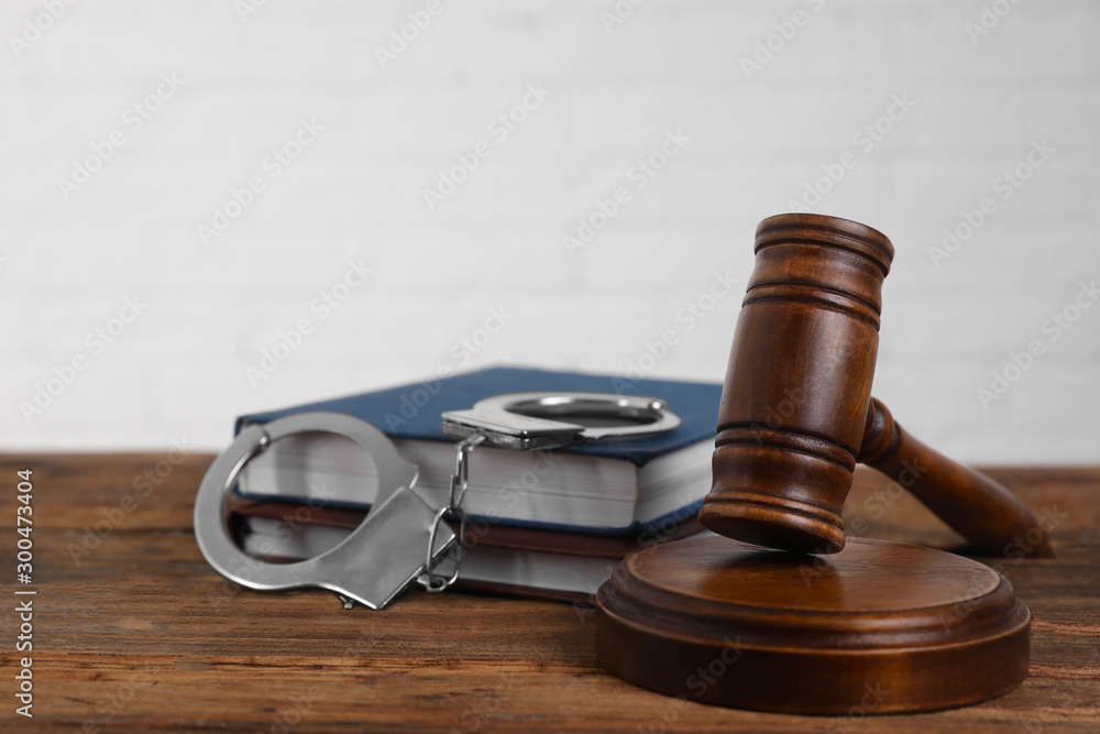 Gavel, handcuffs and books on wooden table. Criminal law Gavel, handcuffs and books on wooden table. Criminal law