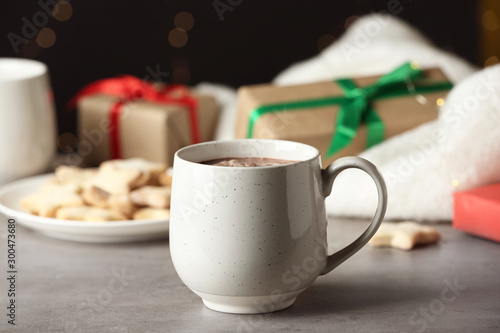 Delicious hot cocoa drink in white cup on grey table