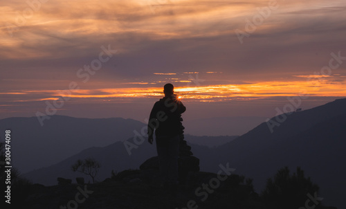Silhueta de homem ao pôr do sol na montanha