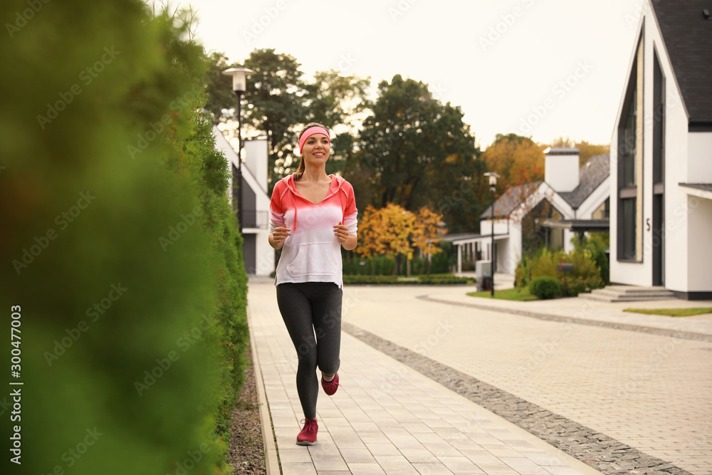 Beautiful sporty woman running on street. Healthy lifestyle