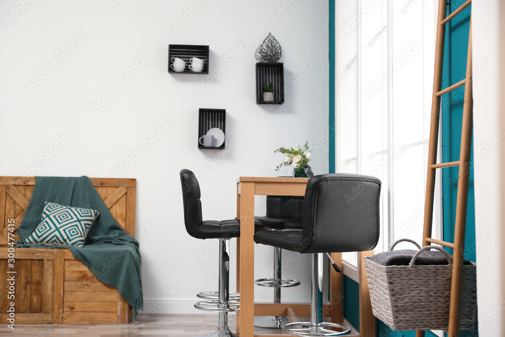 Obraz premium Elegant room interior with wooden table and bar chairs