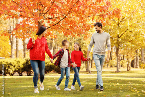 Happy family with children walking in autumn park © New Africa