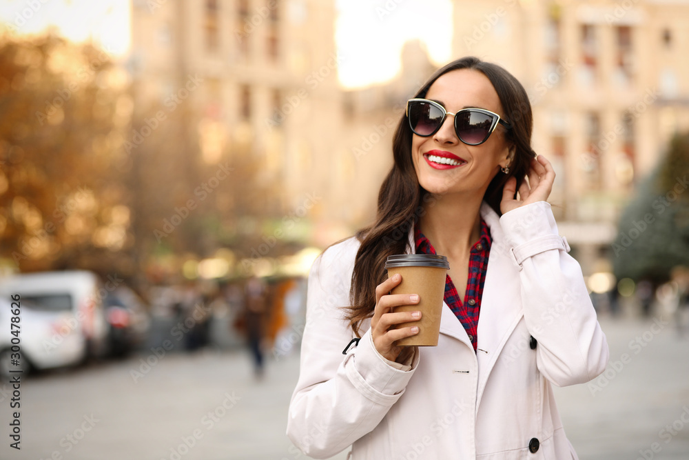 Beautiful woman with cup of coffee on city street. Autumn walk Beautiful woman with cup of coffee on city street. Autumn walk
