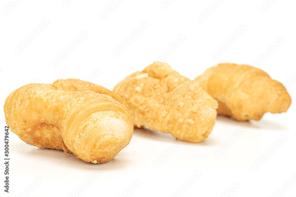 Group of three whole fresh baked mini croissant in row isolated on white background