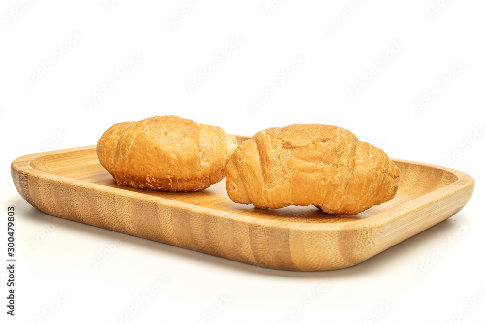 Group of two whole fresh baked mini croissant on wooden square plate isolated on white background Group of two whole fresh baked mini croissant on wooden square plate isolated on white background