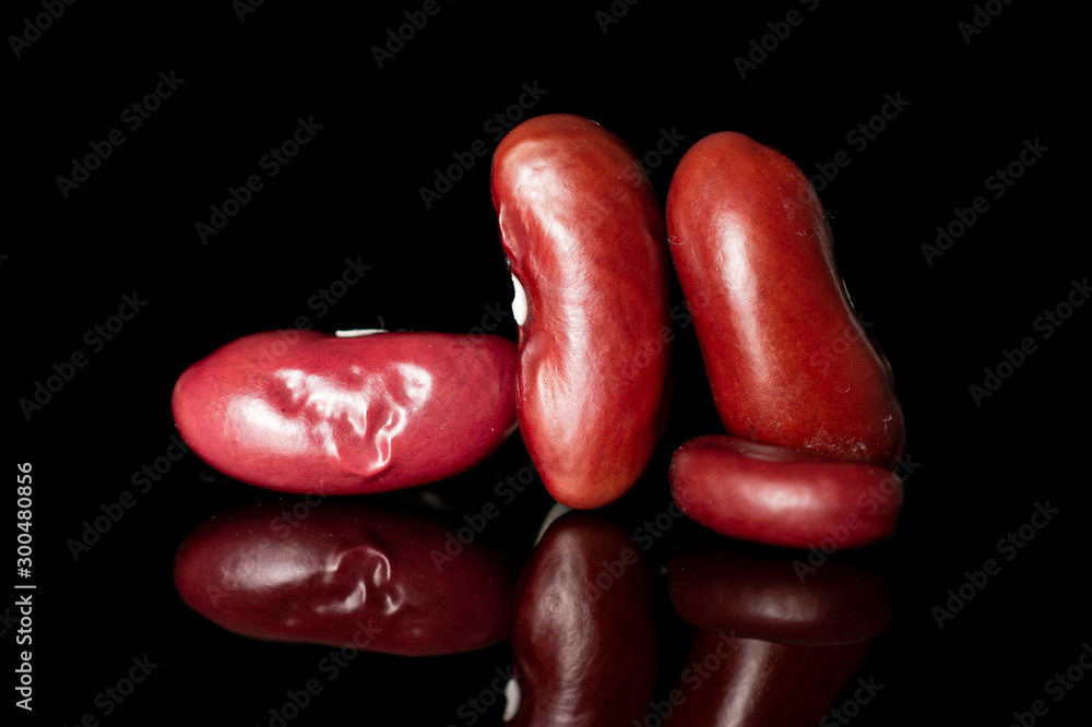 Group of four whole fresh red kidney beans isolated on black glass Group of four whole fresh red kidney beans isolated on black glass