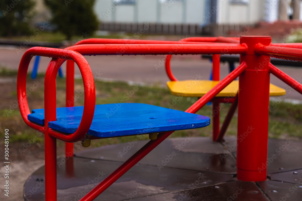 Empty children's swing red color close-up. The concept of sadness, loss, death, mourning, orphanhood or loneliness. Empty children's swing red color close-up. The concept of sadness, loss, death, mourning, orphanhood or loneliness.