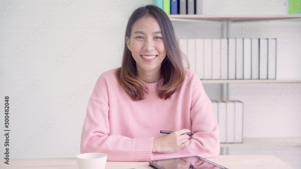 Portrait Asian friendly businesswoman feeling happy in room at home office. Young undergraduate teen girl relax toothy smile looking to camera at house. Social media influencer people or content maker Portrait Asian friendly businesswoman feeling happy in room at home office. Young undergraduate teen girl relax toothy smile looking to camera at house. Social media influencer people or content maker