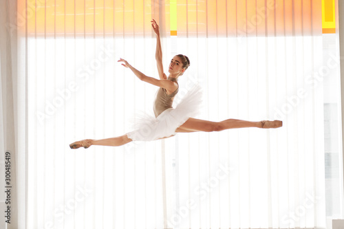 Fototapeta Naklejka Na Ścianę i Meble -  young female ballet dancer at the studio jumping