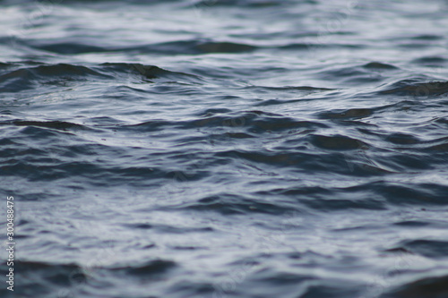 Beautiful   blue sea water surface with low waves. Seascape background. Calm Dark Sea Waves. Close-up  shallow focus.