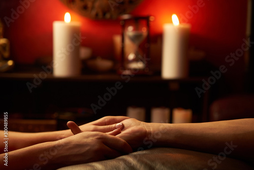 A woman does acupressure fingers for a man. hand massage with intimate lighting. Prelude before making love. Close. Complete relaxation