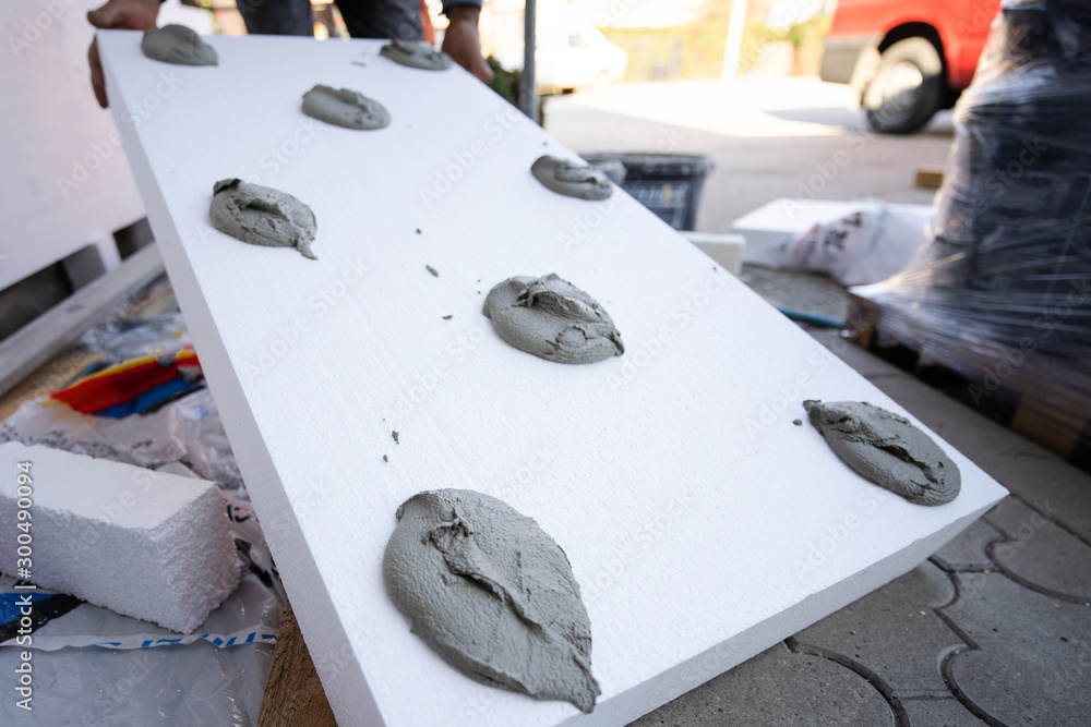 Worker Hand Holding Panel With Applied Cement Adhesive Glue On
