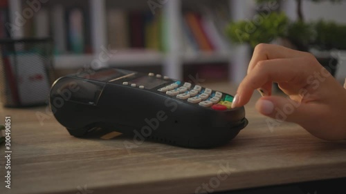 Indoors hands woman paying by credit card swiping with credit card on pos payment terminal on table customer machine money terminal cash client electronic slow motion
