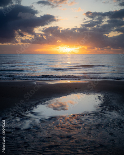 Sunrise reflections over beach