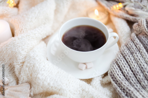 Warm knitted blanket, cup of coffee, marshmallows, Christmas lights, vintage toy, candles