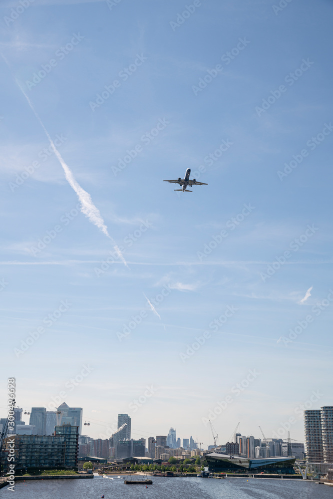 Airplane flying over London and coming in to land.  