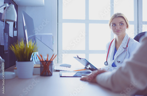 A doctor is talking and examining a patient