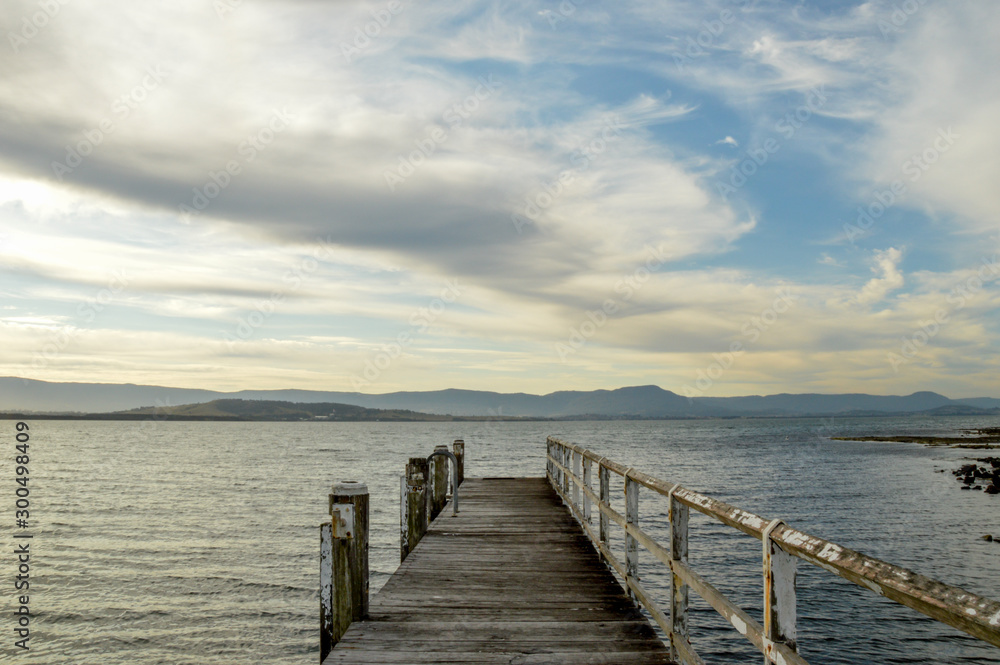 Old timber pier leading to lake with cloudy sky Old timber pier leading to lake with cloudy sky