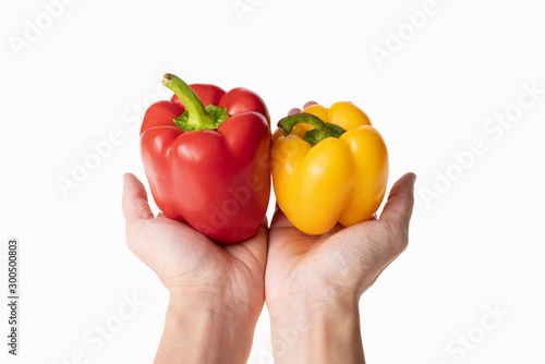 closeup of holding pepper and paprika in hand with white background