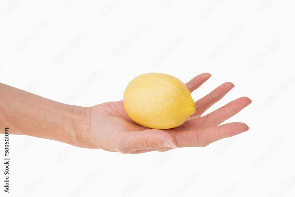 closeup of holding one fresh lemon in hand with white background closeup of holding one fresh lemon in hand with white background