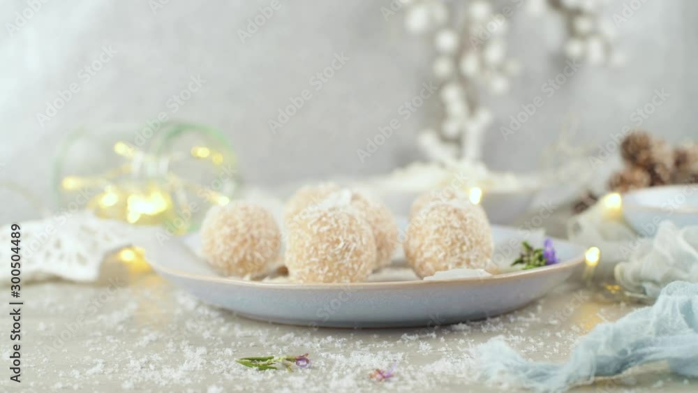 Homemade candies with coconut roasted almonds on a Christmas season table decorated with lights and stars. Homemade candies with coconut roasted almonds on a Christmas season table decorated with lights and stars.