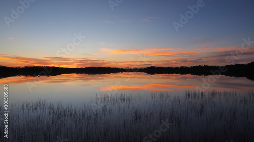 Sunrise cloudscape reflected on calm water of Nine Mile Pond in Everglades National Park, Florida.