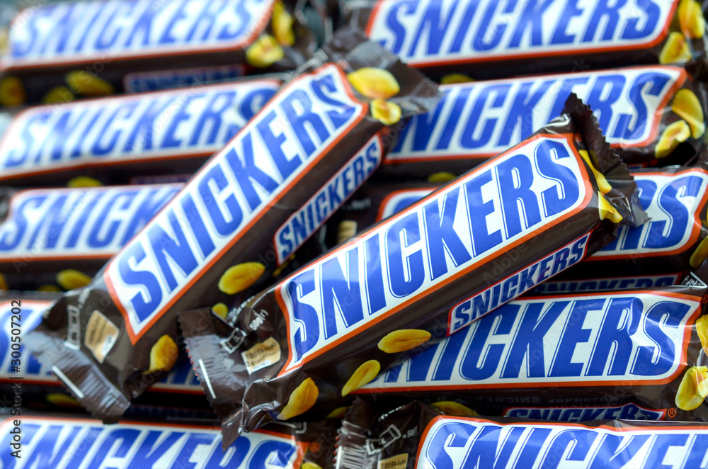 Many Snickers chocolate bars stacked close up. Snickers bars are ...