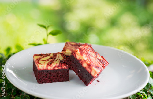 Red velvet cream cheese brownies on white dish