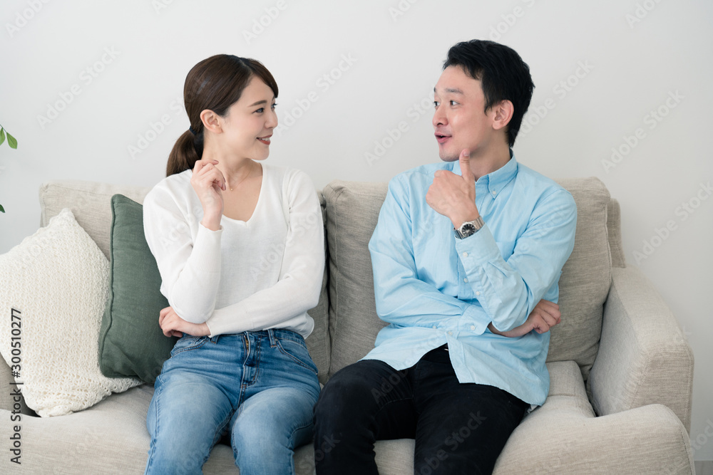 ソファーで話し合っている若い男女 ソファーで話し合っている若い男女