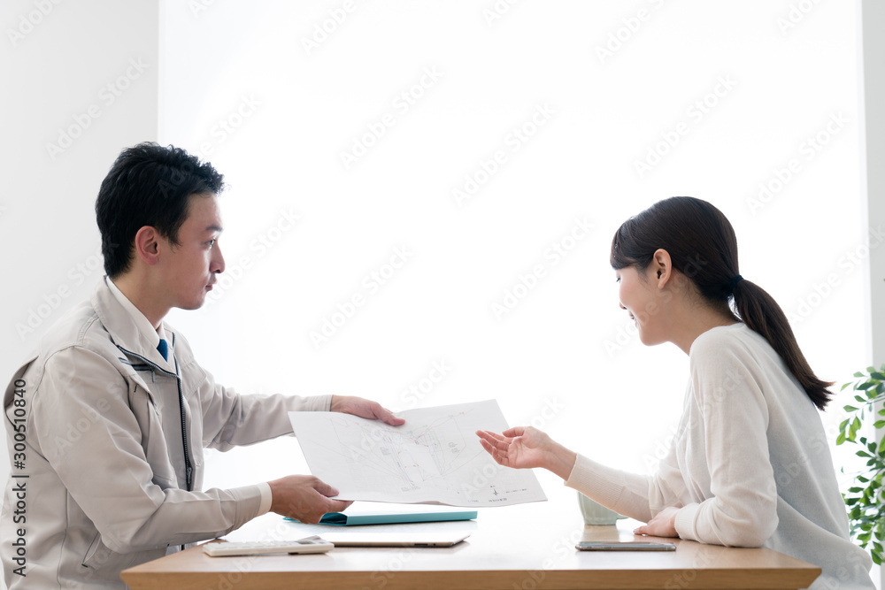 Obraz premium 顧客に設計プランを見せるビジネスマン