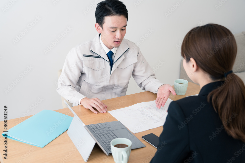 施工計画の打ち合わせをするビジネスマンとビジネスウーマン 施工計画の打ち合わせをするビジネスマンとビジネスウーマン