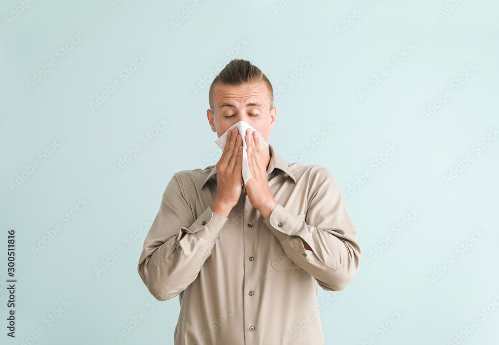 Young man suffering from allergy on light background Young man suffering from allergy on light background