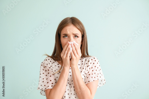 Young woman suffering from allergy on light background photo