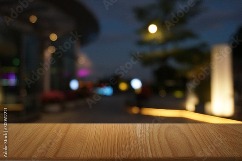Empty dark wooden table in front of abstract blurred bokeh background of restaurant . can be used for display or montage your products.Mock up for space.