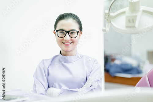 Portrait of female dentist .She standing in her dentist office.